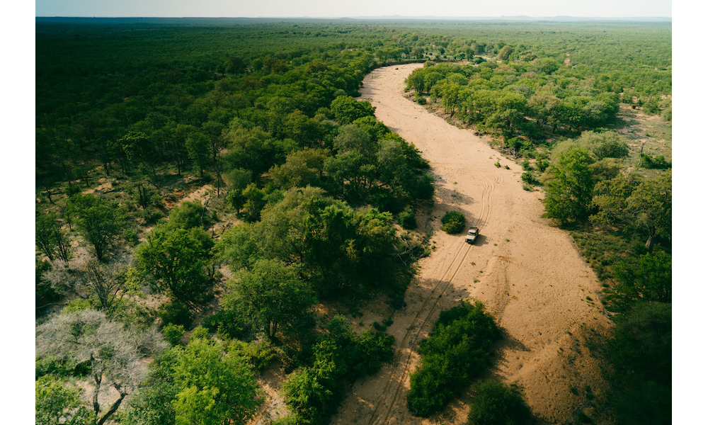 Aerial shot of ranger vehicle in river bed in Venetia Limpopo Nature Reserve, part of the Diamond Route, South Africa